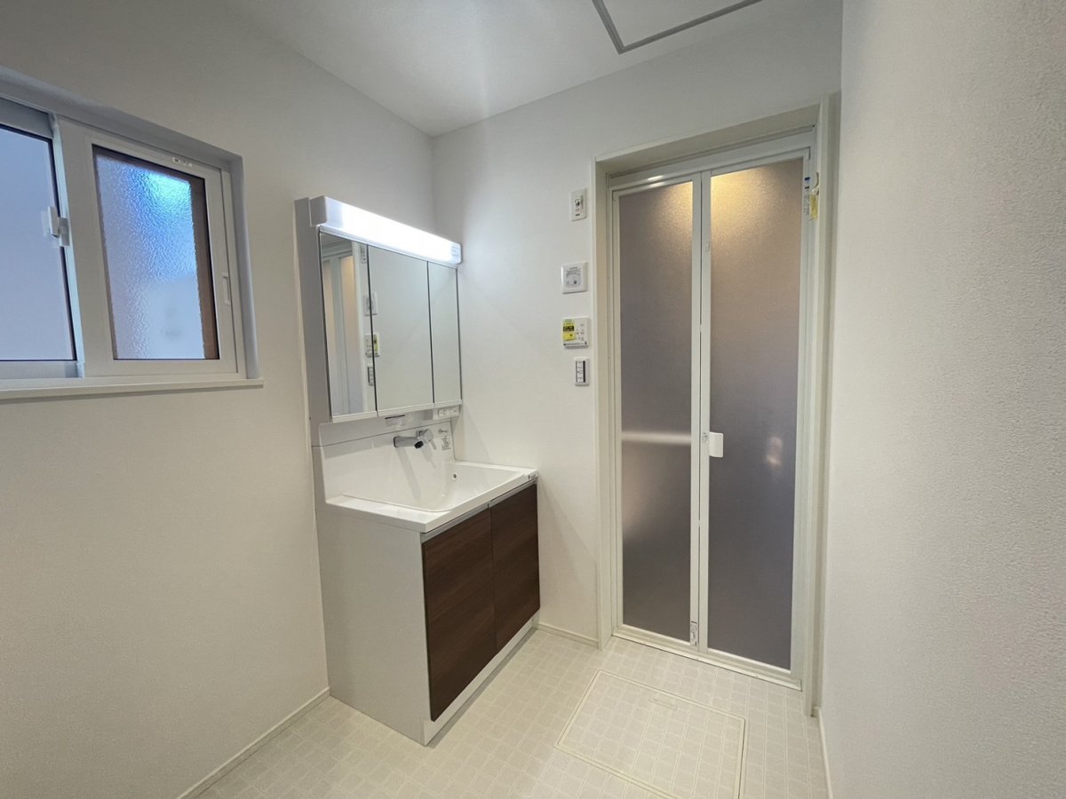 洗面脱衣室　ゆとりの洗面スペースで朝の身支度もスムーズに。三面鏡の中には収納があるため、いつでもすっきりした見た目で過ごせます。
